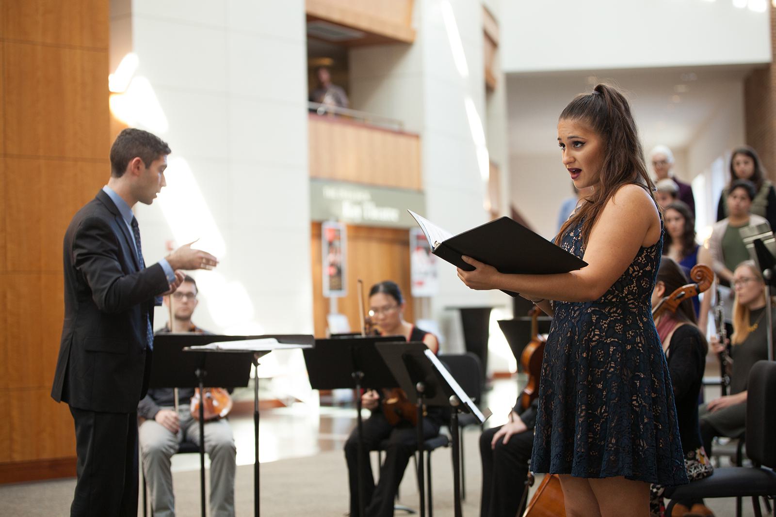 A woman sings a solo during a choral performance.