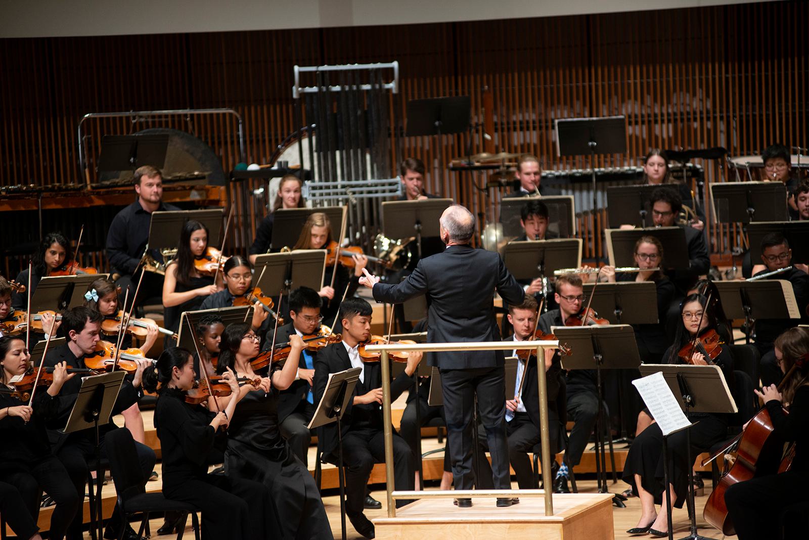 A man conducts an orchestra.