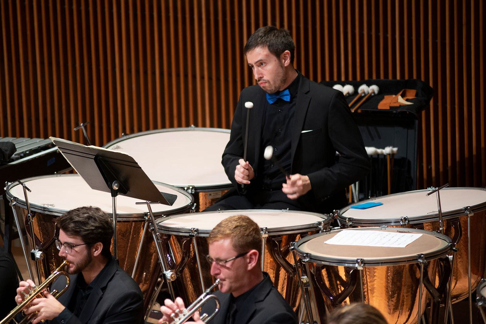 Students play drums and trumpets.