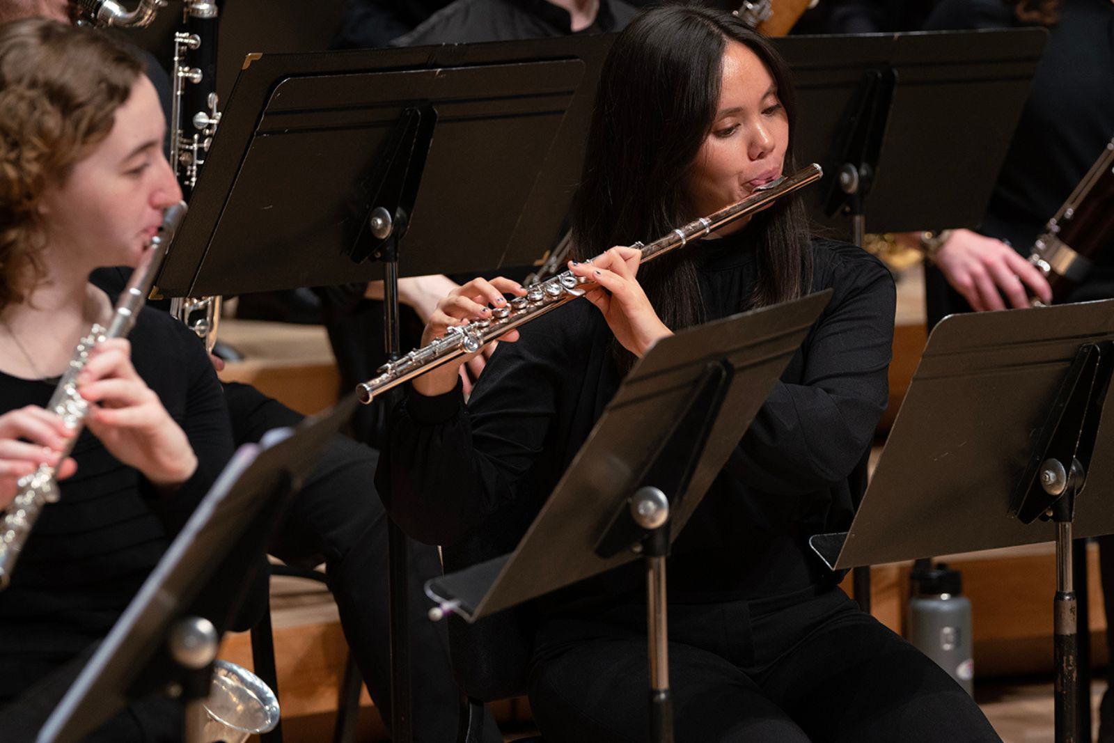 Members of the UMD Wind Orchestra play flutes during a performance.