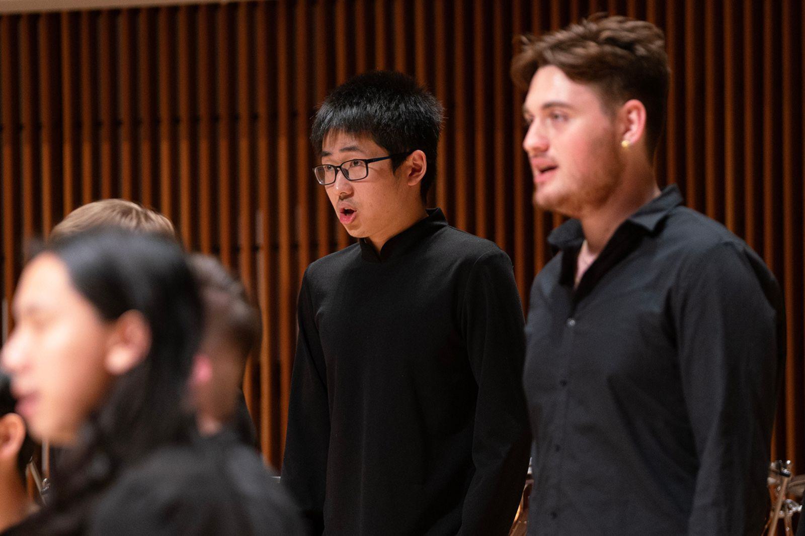 Two men sing in a choir.