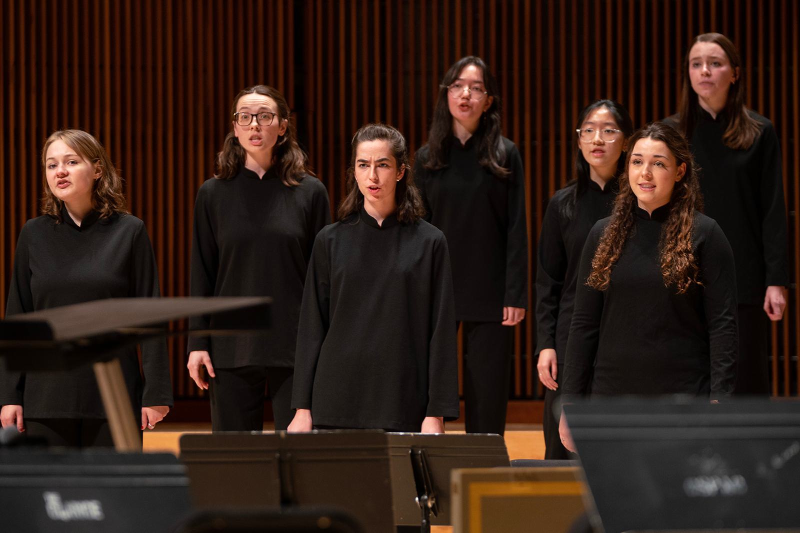 Members of a choir sing together on stage.