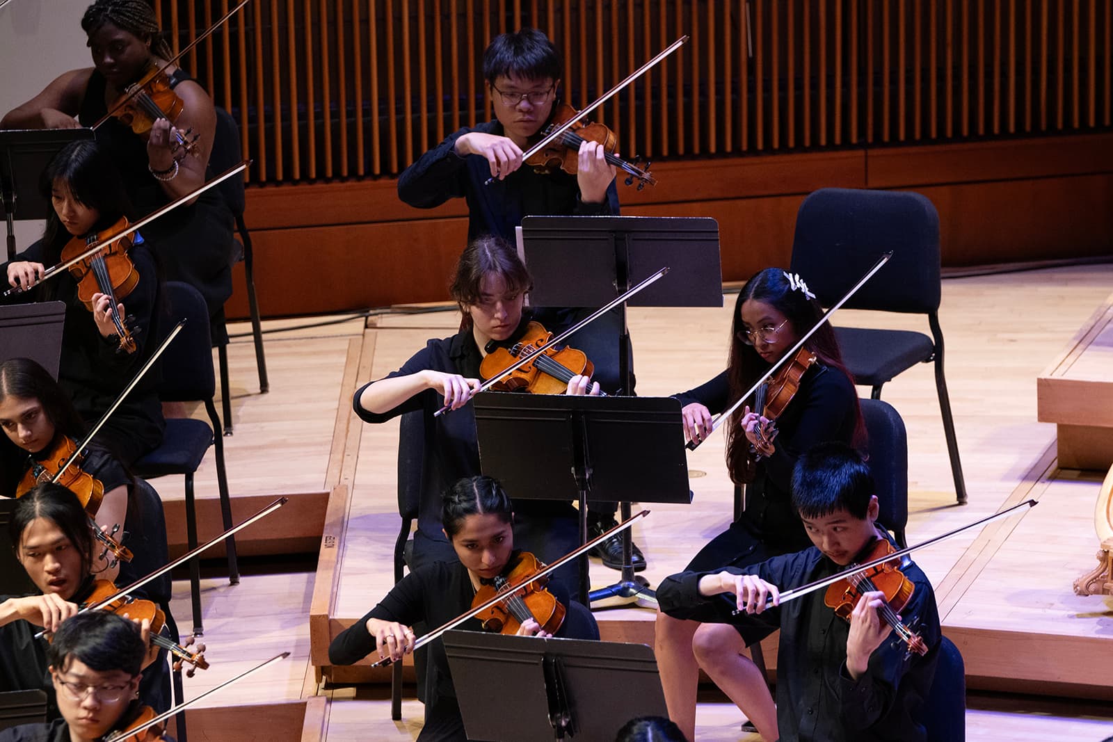 Student musicians in a concert hall performing.