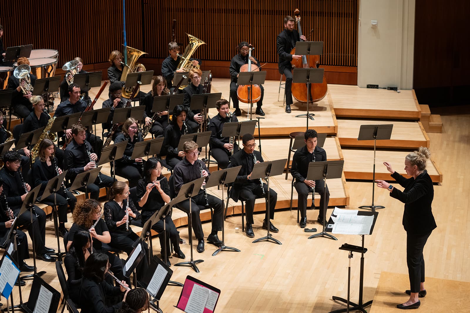 Artists performing in a music hall facing their conductor.