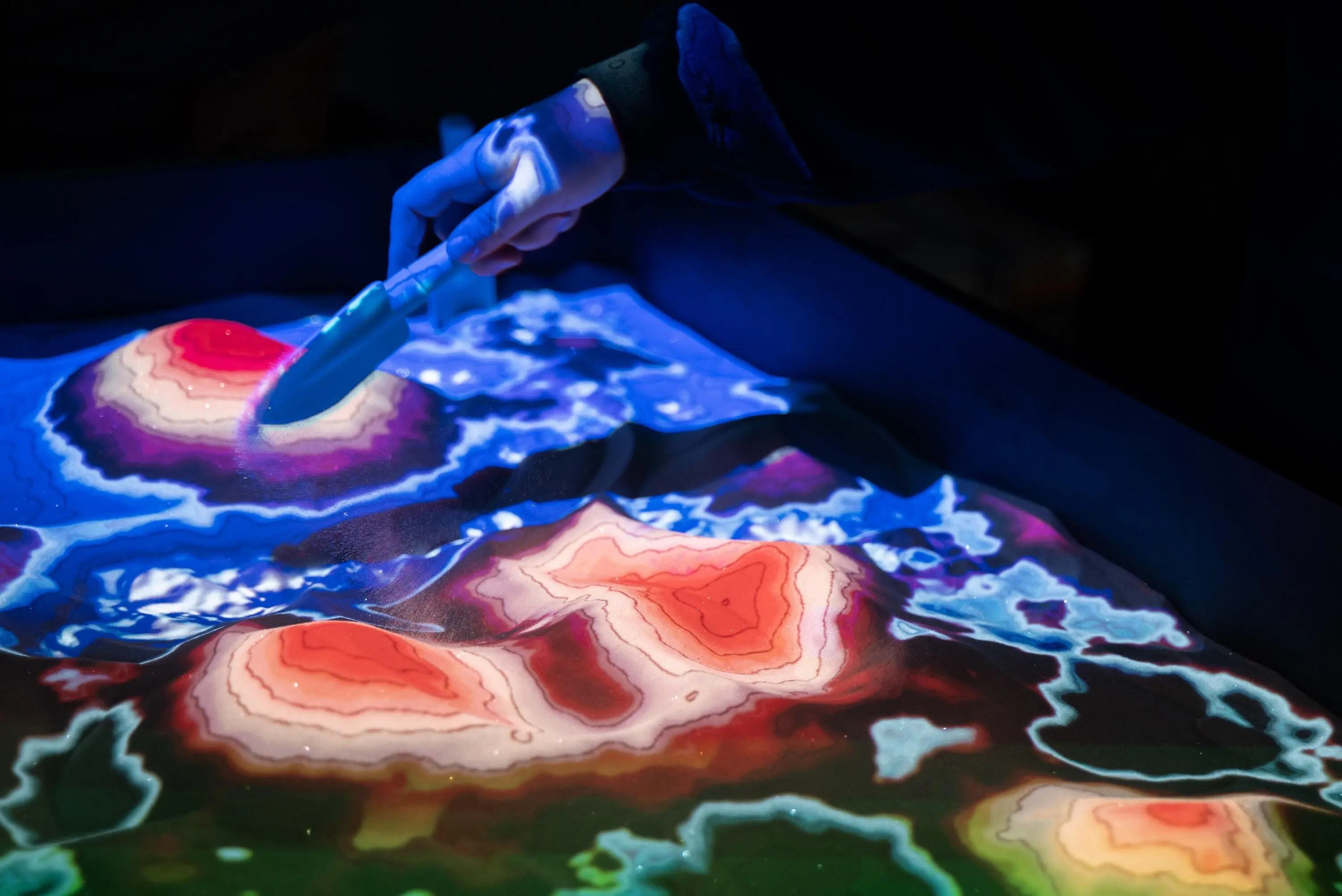 AR sandbox model, the sand reflects different colors depending on the altitude it represents