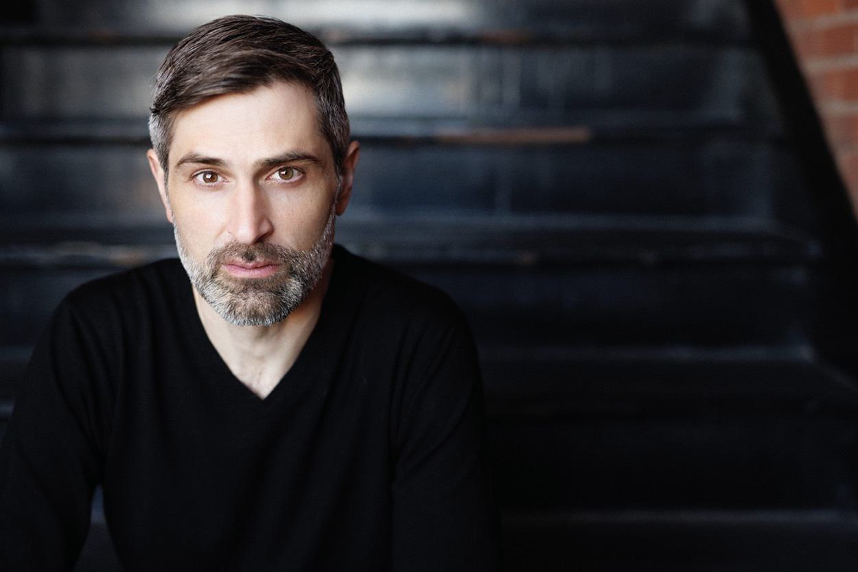 Ali Kian Yazdanfar poses on a staircase for a headshot.