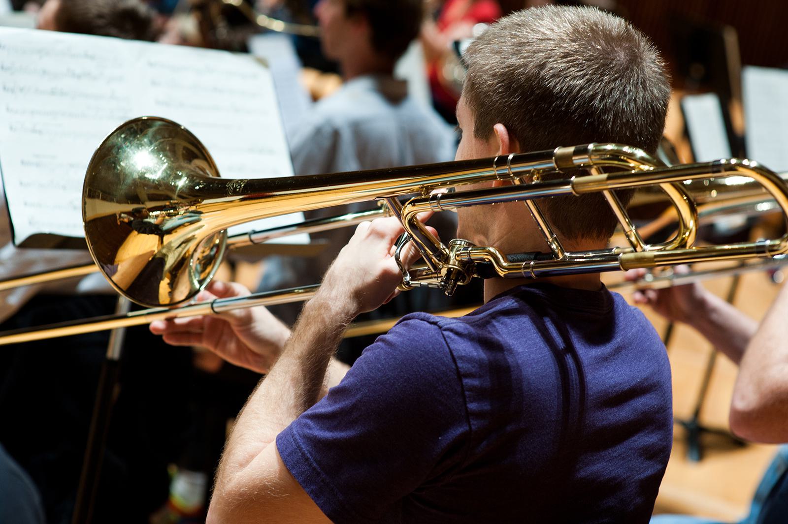 A student plays a trombone during a concert.