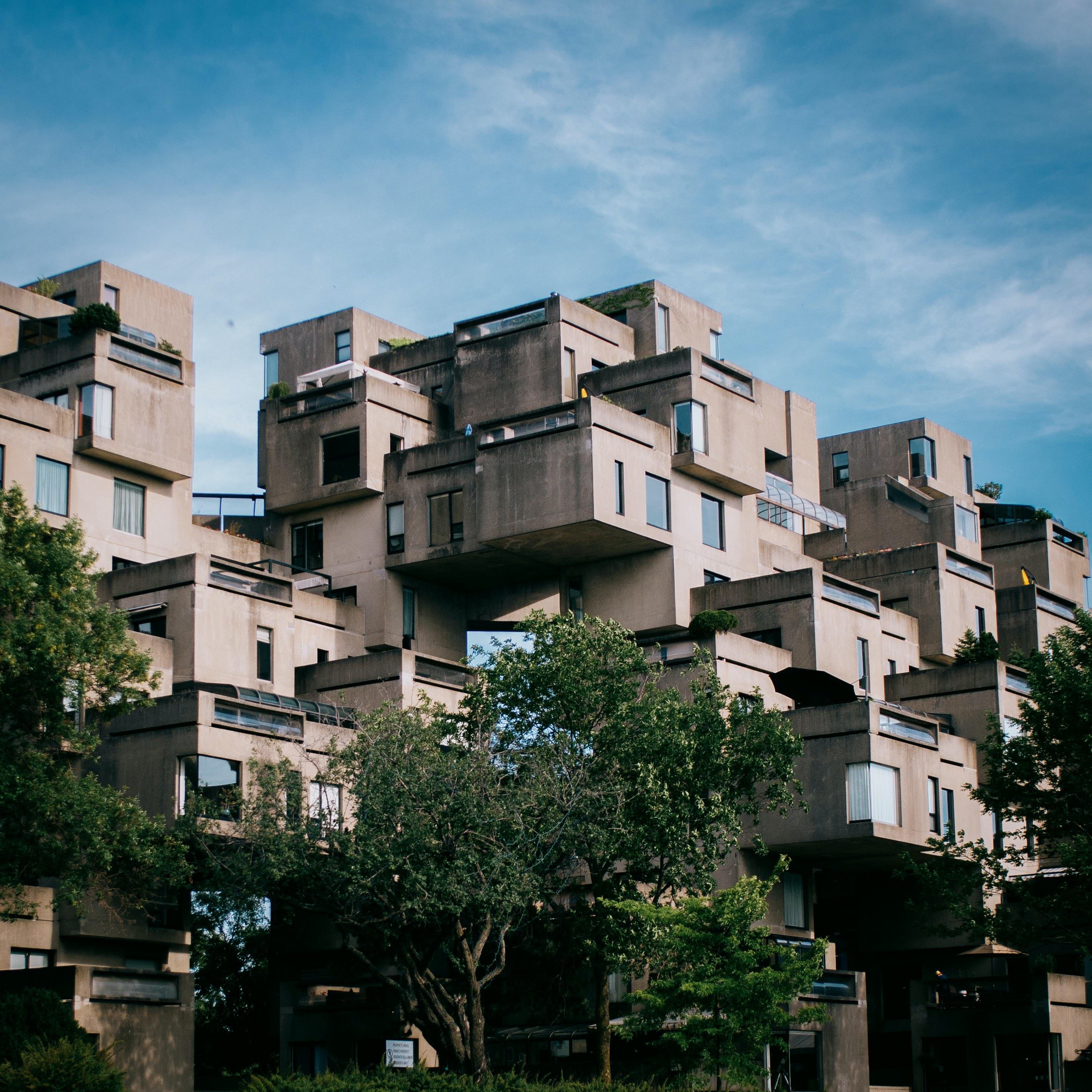 Cube-like building with trees in the foreground.