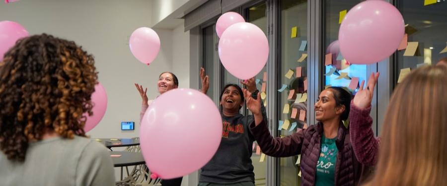 Students playing with pink balloons