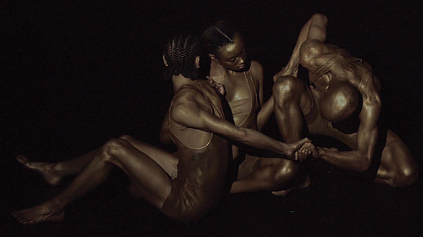 Three dancers entwined.