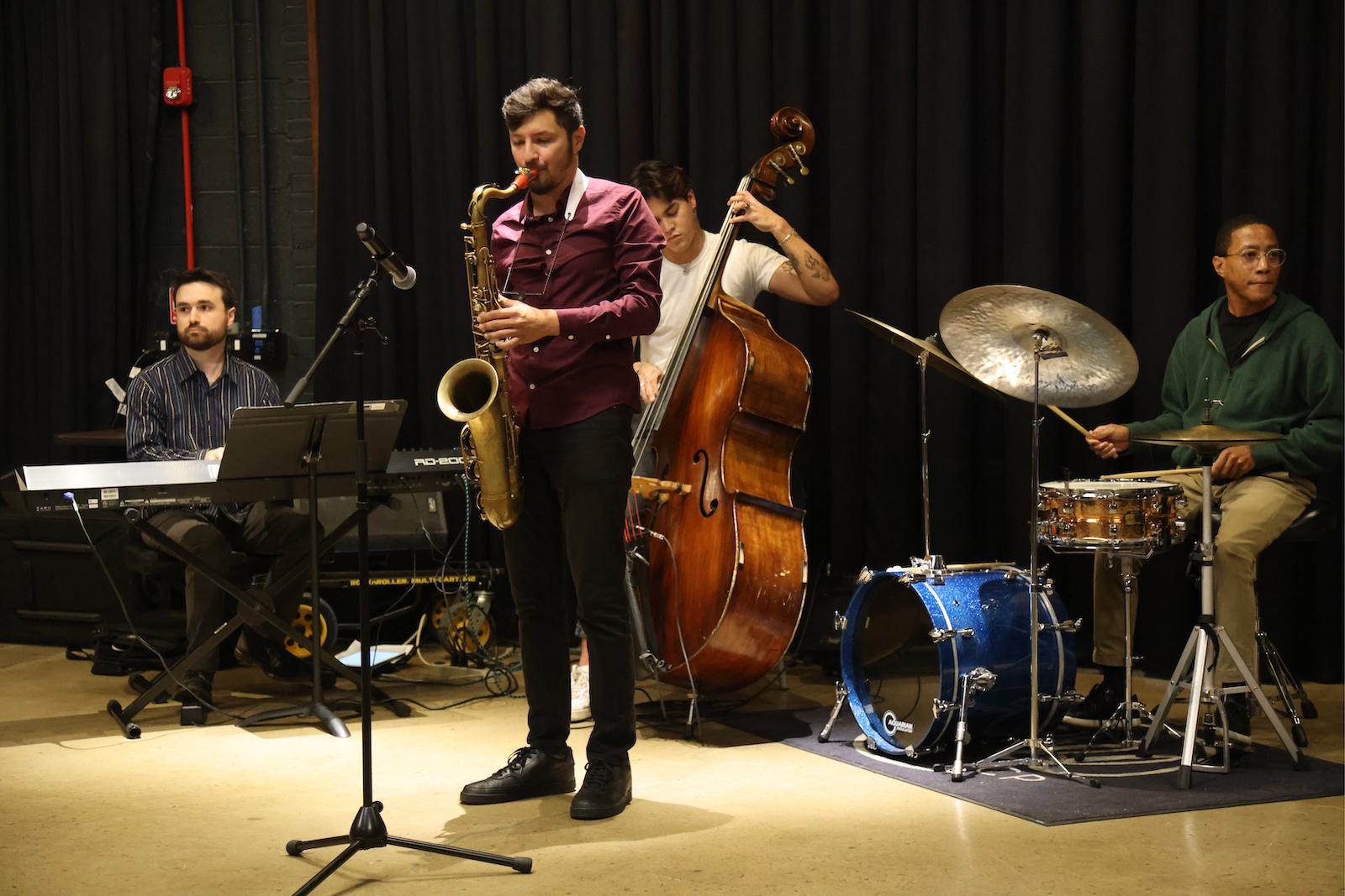 A small band plays various instruments during a performance.