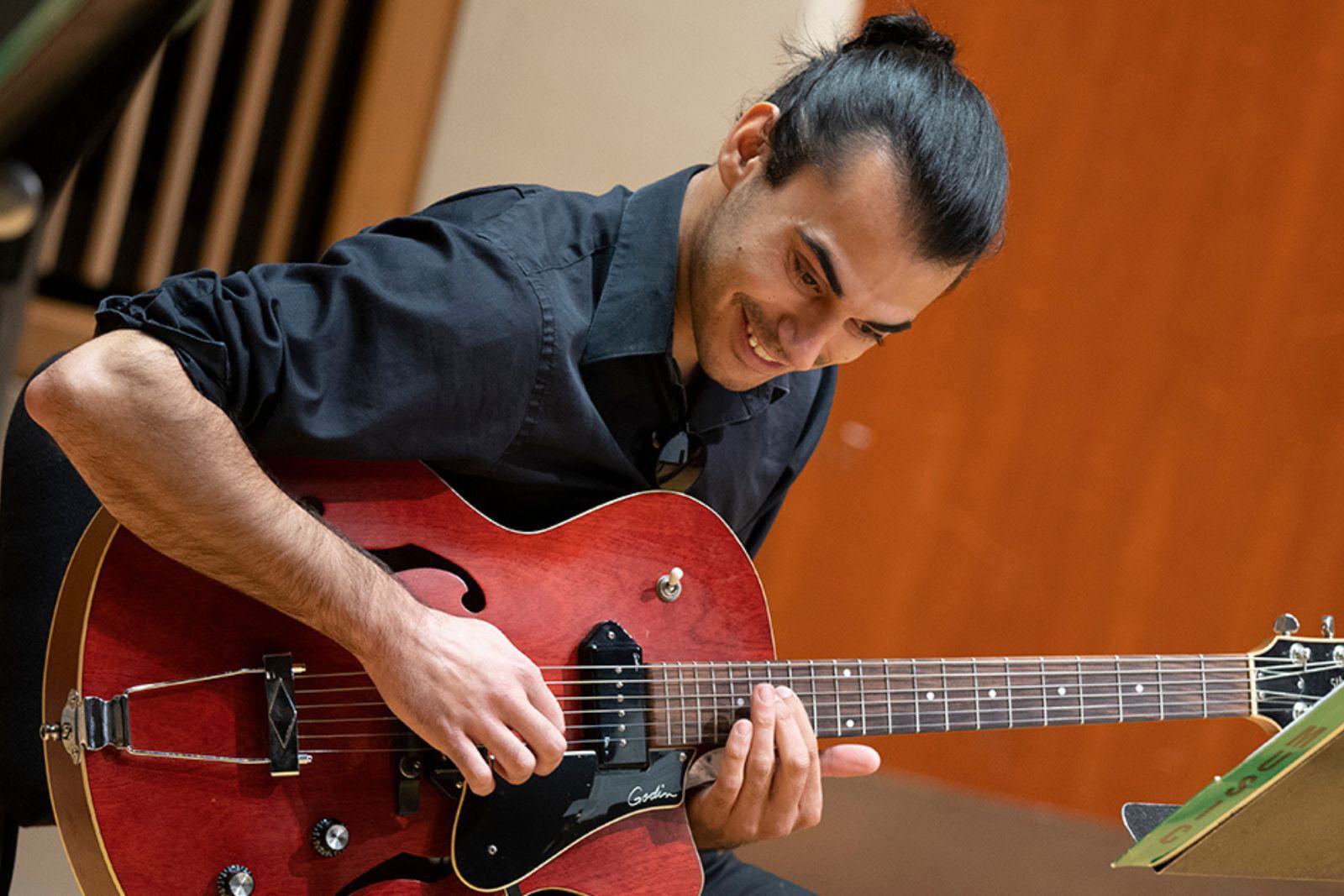 A jazz student plays an electric guitar.