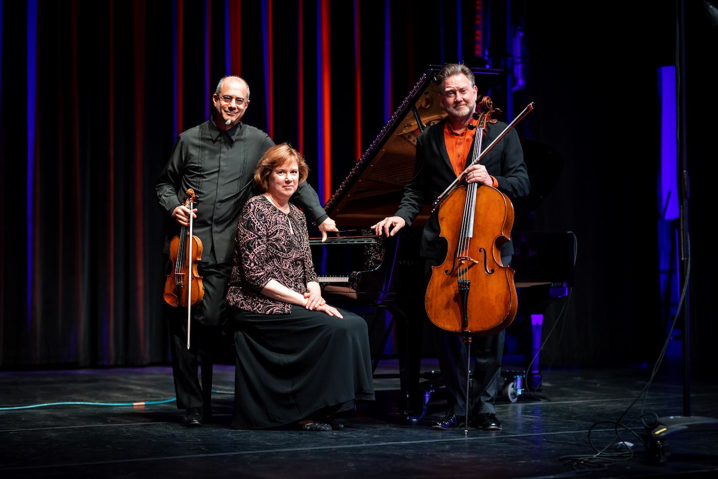 Members of the Andrist-Stern-Honigberg Trio pose with their instruments for a picture on stage.