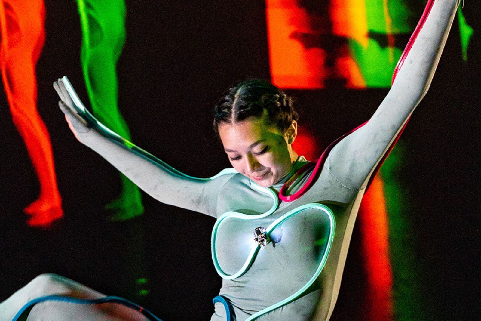 A dancer wears a tiny robot attached to her outfit.