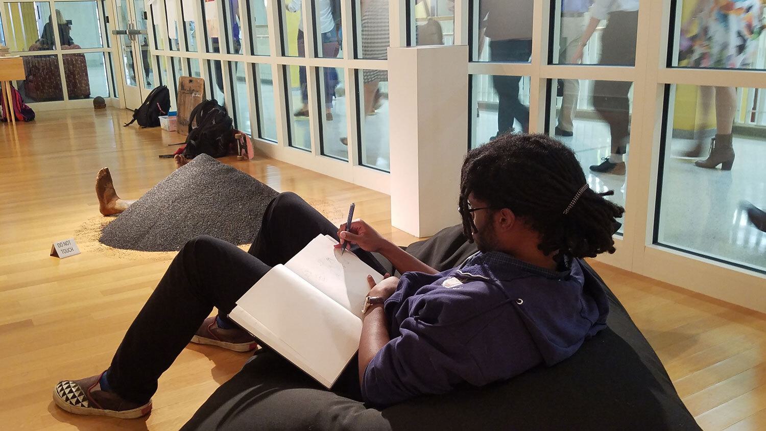 A photo of a student sketching in the Stamp Gallery