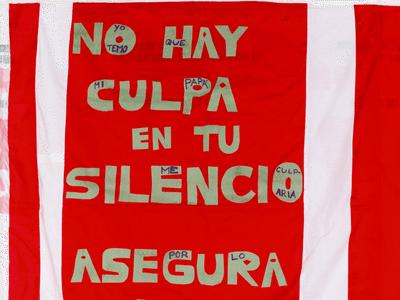 Image of red quilt that reads "No Hay Culpa in tu Silencio"