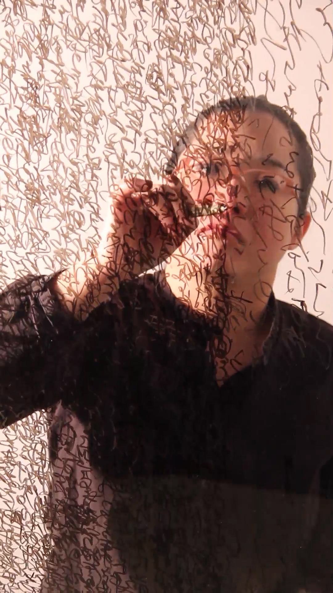 Image shows still from Mami Takashi's art piece titled "Writing Myself".