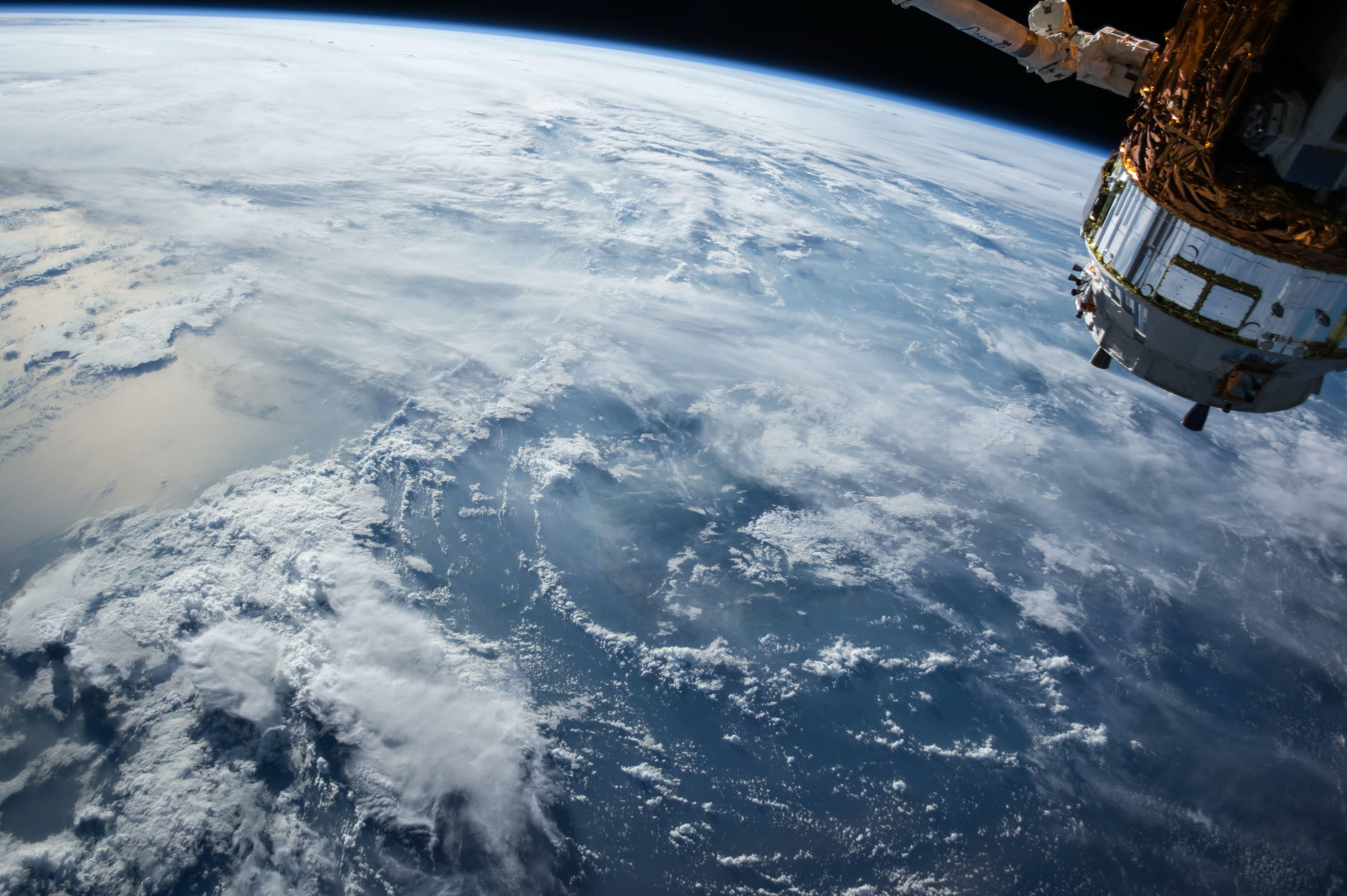 an image of earth with the International Space Station in background