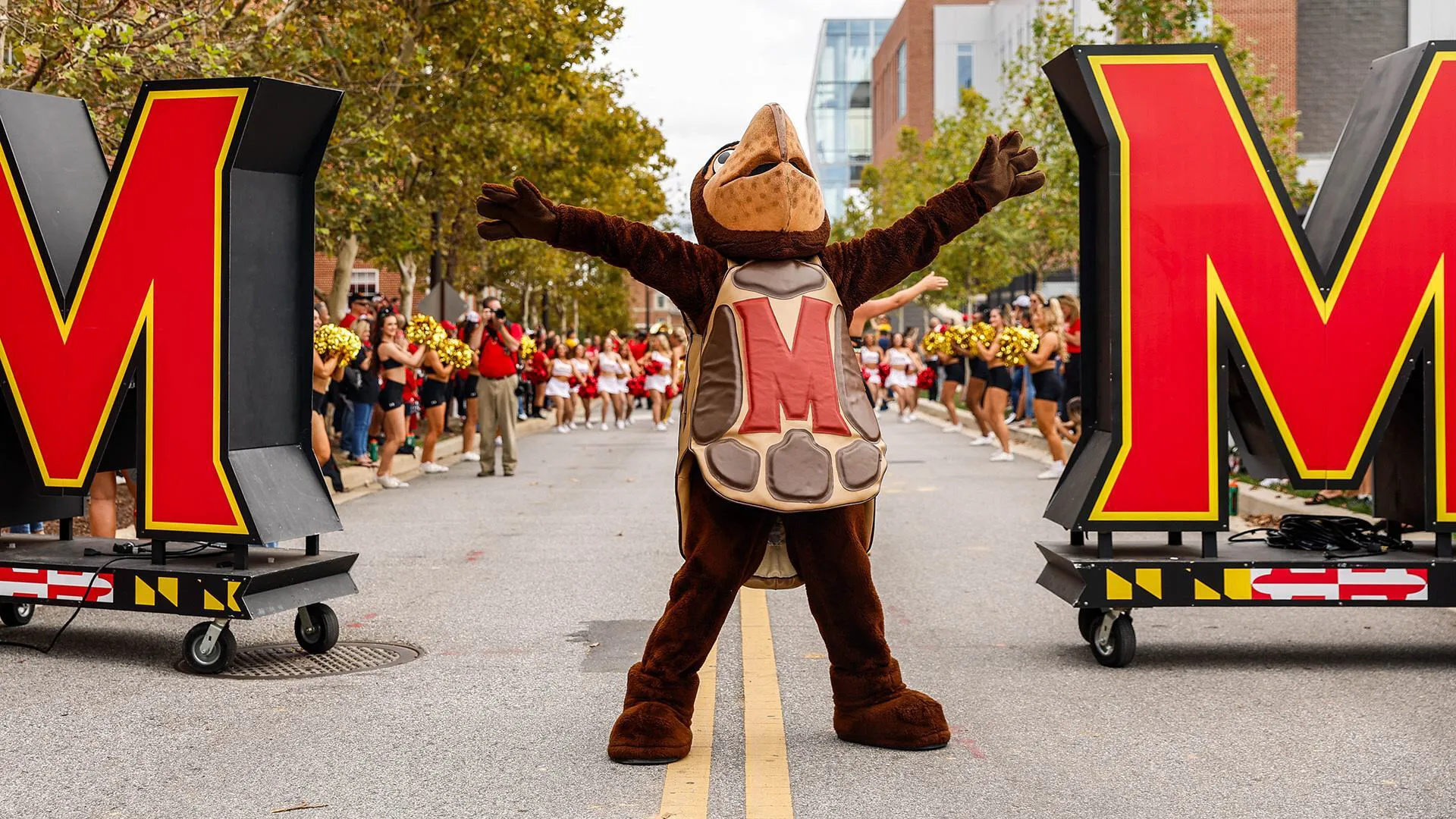 Testudo celebrates and the football team arrives at Terp Alley.