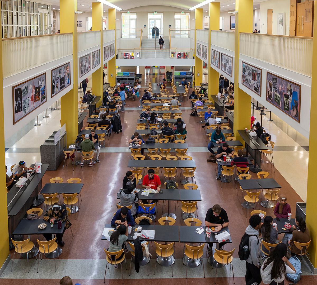 Overlooking the balcony above the Stamp food court, where several groups of students are having a meal.