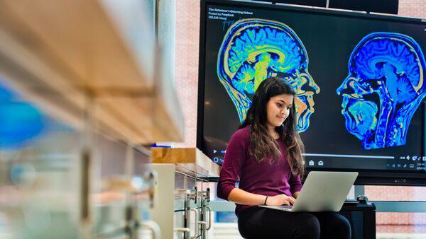 Synapto brain research display and student at the A. James Clark Hall Open House.