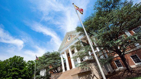 View of the front exterior of Main Administration Building, with the American Flag and Maryland Flag on flagpoles in the foreground.